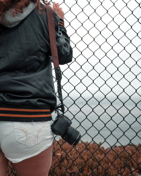 Different ways to use a leather camera strap and camera wrist strap.